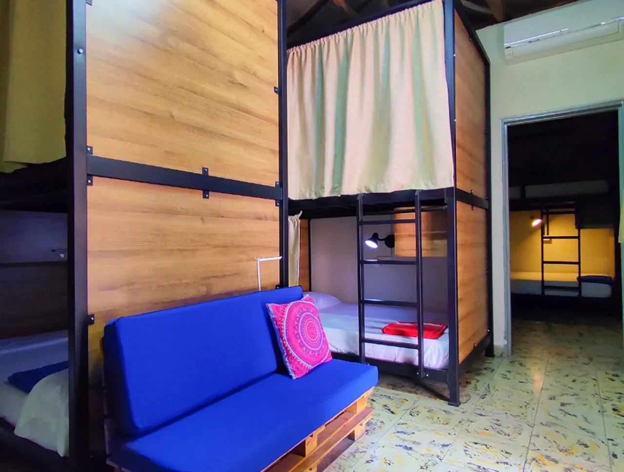 Dormitorio de 8 camas con camarotes y sofá en Trip Monkey Origen