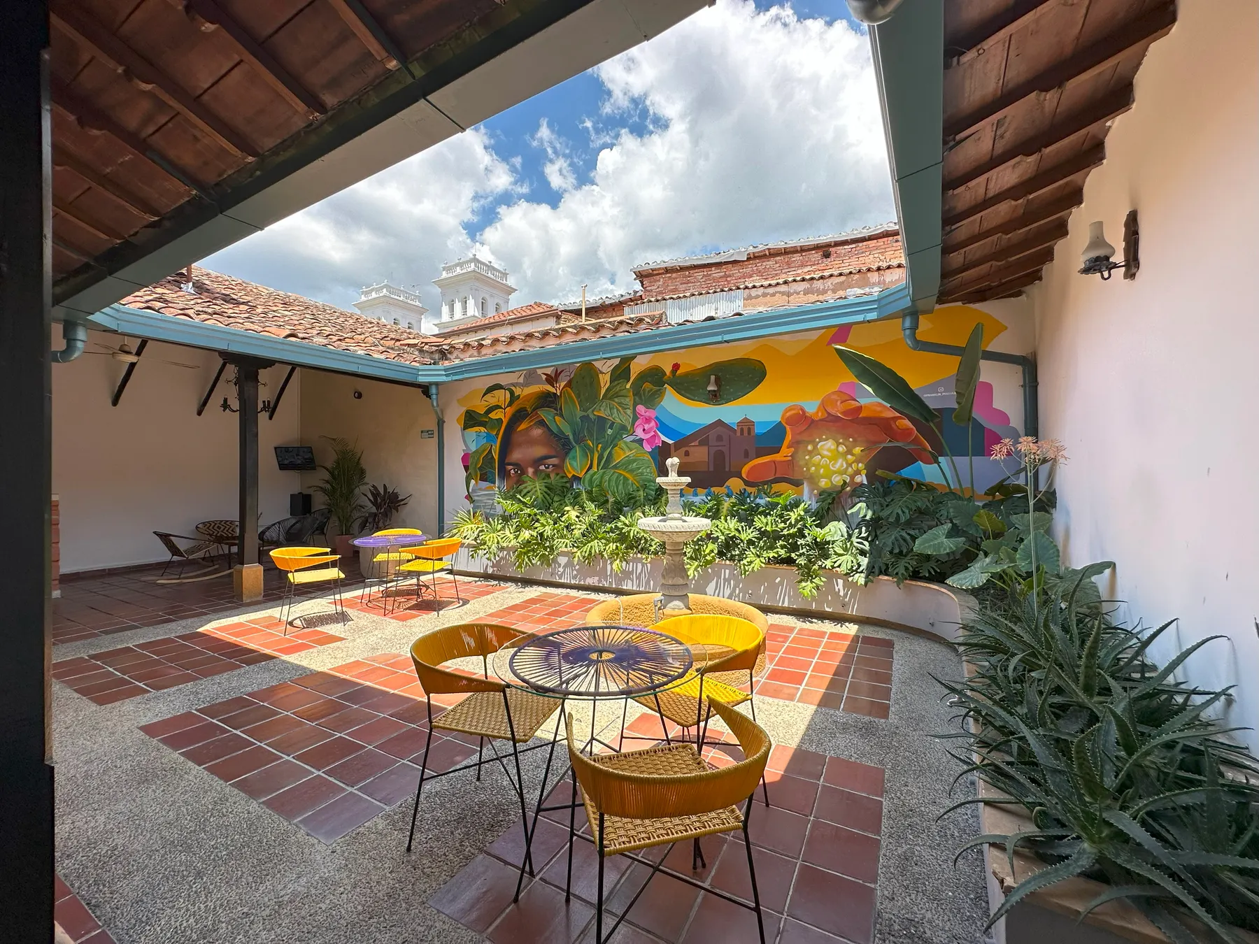 Patio con mural y fuente de Trip Monkey Girón