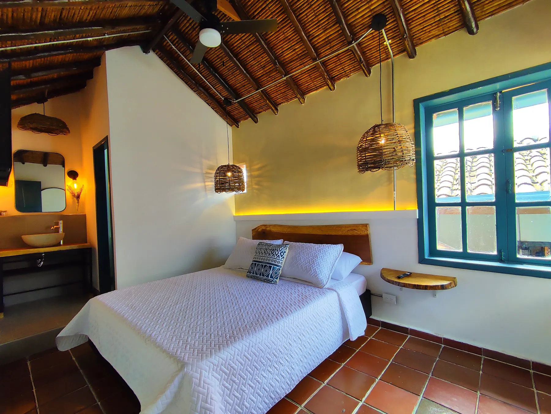 Habitación doble con ventanas azules y techo de madera en Trip Monkey Girón