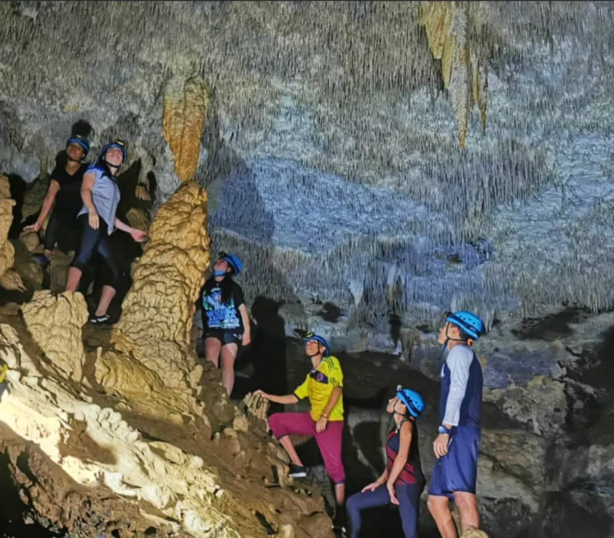Grupo con casco entre estalactitas en la cueva de la Vaca