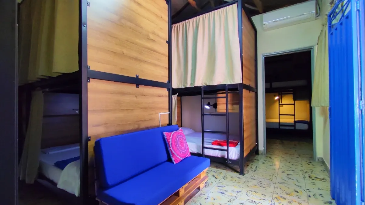 Dormitorio con sofá azul en Trip Monkey Origen