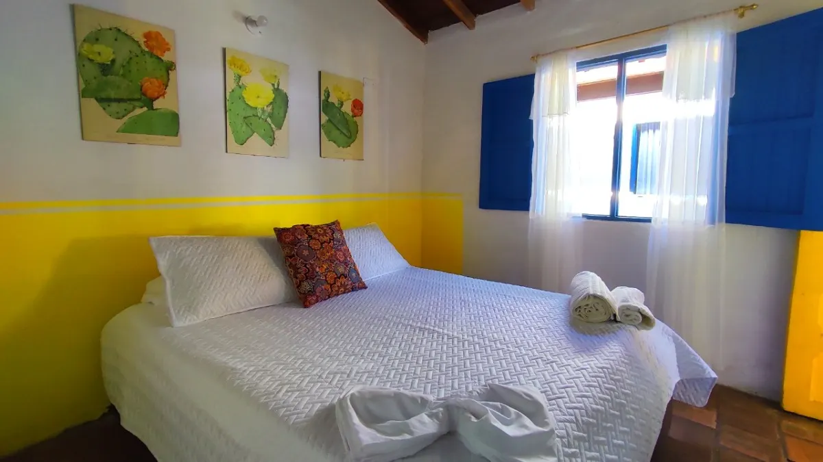 Habitación doble con ventana azul en Trip Monkey Barichara