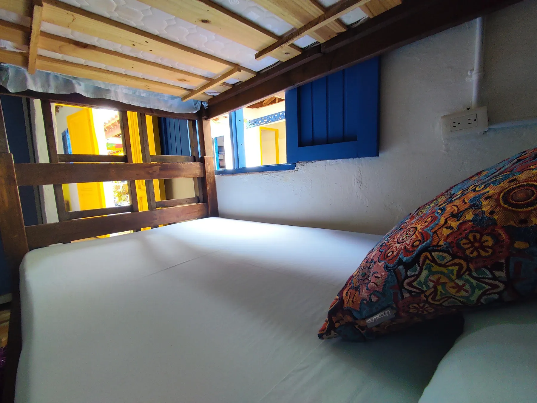 Dormitorio de Trip Monkey Barichara con litera y ventana azul