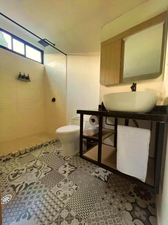 Baño privado con ducha y piso de baldosa decorada en Trip Monkey Del Río