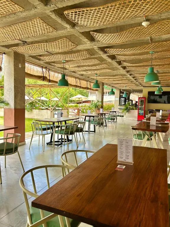 Terraza del restaurante Alaia con mesas y lámparas verdes en Trip Monkey Del Río