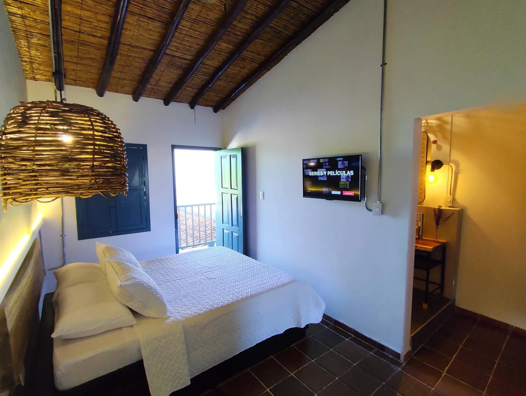 Habitación Doble con balcón de Trip Monkey Girón con la puerta al balcón abierta