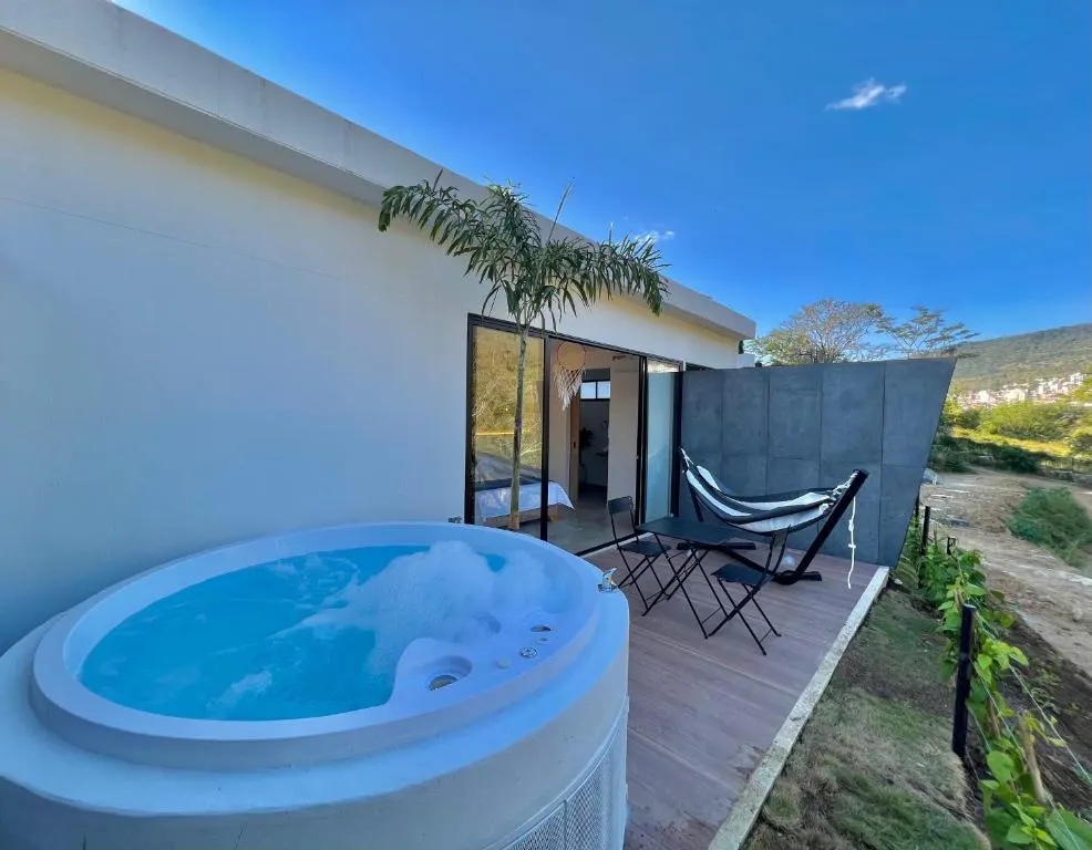 Jacuzzi en la terraza del Glamping Deluxe, con sillas y vista a la montaña