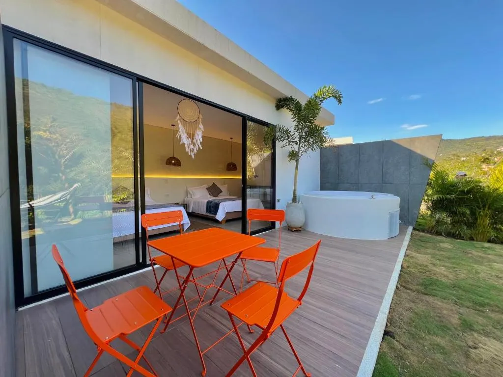 Terraza del Glamping Familiar con mesa, sillas naranjas y jacuzzi