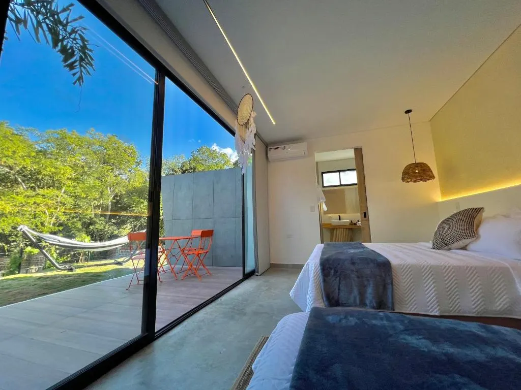 Glamping Familiar con dos camas dobles frente al ventanal y la terraza