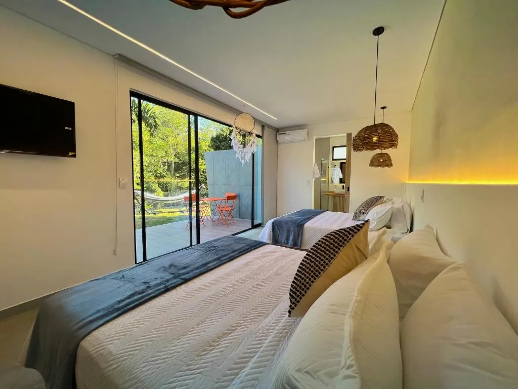 Dos camas dobles del Glamping Familiar, con televisor y aire acondicionado