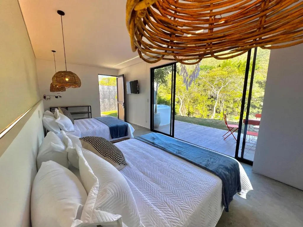 Glamping Familiar con dos camas y vista a la terraza con sillas naranjas