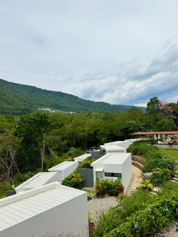 Unidades de glamping en la ladera con la montaña de San Gil al fondo