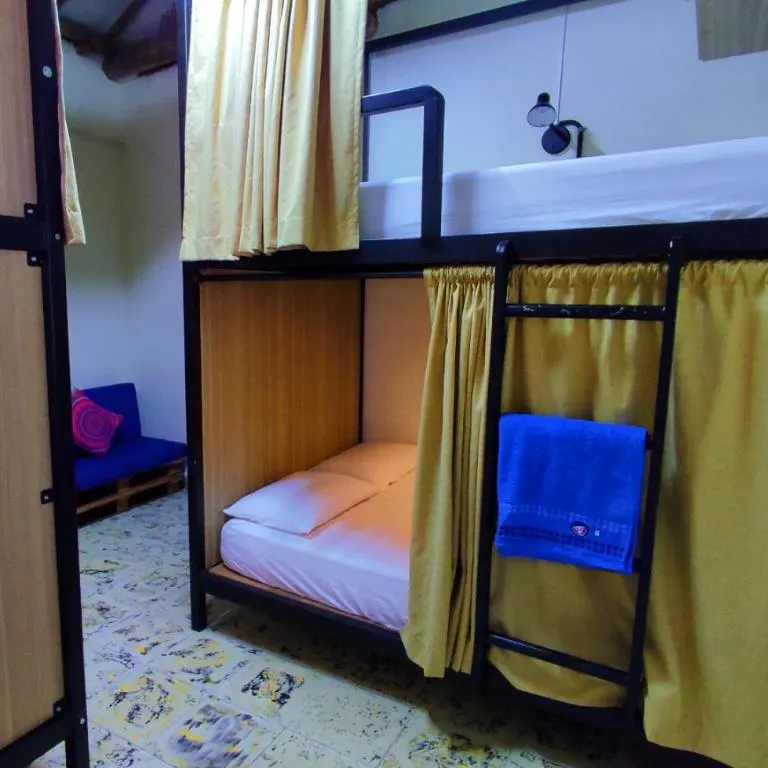 Litera con cortina y toalla en el dormitorio de 10 camas de Trip Monkey Origen