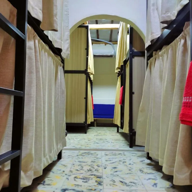 Pasillo del dormitorio de 10 camas de Trip Monkey Origen con literas y cortinas